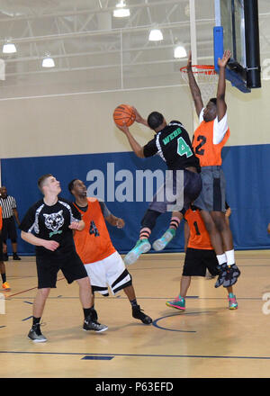 Una guardia di tiro del 2nd Communications Squadron attacca aggressivamente il basket durante la partita di basket del campionato alla Barksdale Air Force base, Louisiana, 14 aprile 2016. Ha segnato 18 punti nella prima partita e 25 nella seconda, dimostrando abilità di segnare, abilità offensiva, agilità, posizionamento strategico, e prestazioni competitive. La partita mette in evidenza il lavoro di squadra, il morale e lo sviluppo atletico negli sport intramurali tra il personale dell'Air Force, sottolineando la pratica, il coordinamento e l'applicazione delle competenze. Foto Stock