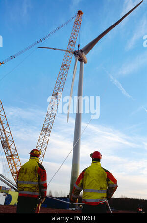 Due tecnici la guida del mozzo e delle pale di una grande Enercon turbina eolica in posizione utilizzando corde. Worksop. Regno Unito. 2008. Foto Stock