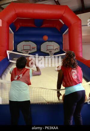 Visitatori shoot hoops durante il giunto Senior leader arruolato campo divertente evento della durata di un giorno presso il Camp Lemonnier, Gibuti, Aprile 29, 2016. Quando la temperatura è salita superiore a 89 gradi, U.S. Embassy famiglie e volontari spostato al coperto per gustare il pranzo, musica, balli e altro ancora. (U.S. Air Force foto di Senior Airman Benjamin Raughton/rilasciato) Foto Stock