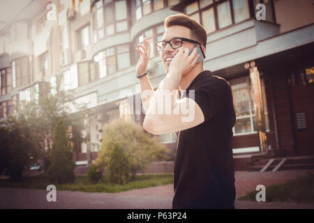Allegro giovane uomo agitando la mano per dire ciao Foto Stock