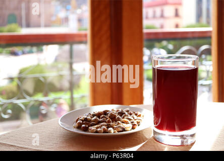 Chicha Morada, popolare tradizionale peruviana drinks serviti con una piastra di andina mais tostato Foto Stock