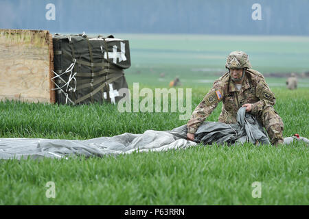 Stati Uniti Esercito Lt. Col. Benjamin Bennett, Comandante della brigata 54th Engineer battaglione, 173rd Brigata Aerea, passaggi il suo paracadute durante grandi operazioni aviotrasportate come parte di esercizio Saber Junction 16 sulla manovra diritti Area vicino Hohenfels, Germania, 12 aprile 2016. Oltre mille paracadutisti e contenitore di molteplici sistemi di consegna fasci venivano impiegati per fornire iniziale di supporto logistico per seguire le missioni. Saber Junction 16 valuterà e a valutare la disponibilità degli Stati Uniti Dell'esercito 173rd Airborne Brigade di condurre le operazioni di terra in un giunto, combinata ambiente e al fine di promuovere Foto Stock