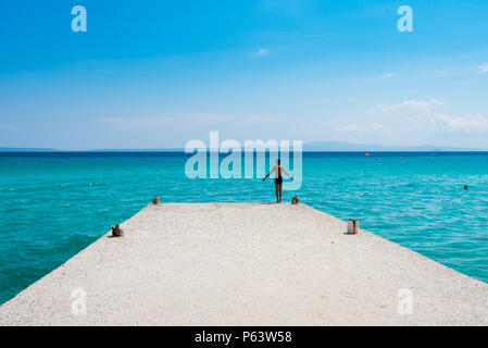 Chaniotis, Grecia - 23 giugno 2018:Giovane ragazzo in preparazione al salto in mare in una giornata di sole Foto Stock