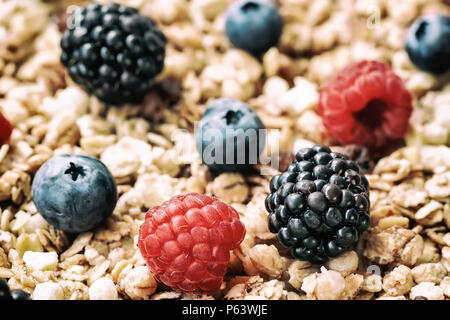 Lampone, mirtilli, more close-up su sfondo di muesli. Una sana prima colazione, proprio lifestyle, detox, vitamine, dieta Foto Stock