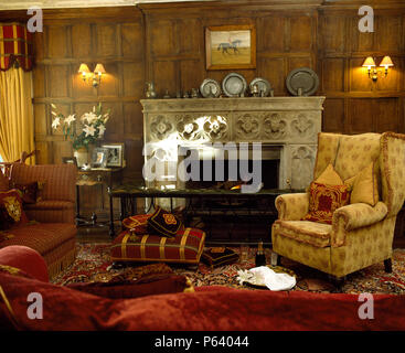 Sedia ad ala nella sala con caminetto Foto stock - Alamy