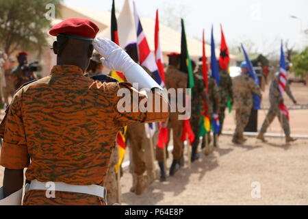 Un funzionario dal Burkina Faso esercito saluta come bandiere internazionali marzo passato lui durante il Western Accord 16 Apertura cerimonia del giorno 2 maggio 2016 presso il Camp Zagre, Ouagadougou, Burkina Faso. Western Accord 16 è un annuale combinati, esercizio congiunto progettato per aumentare la capacità dei partner africani e le forze degli Stati Uniti di esercitare i partecipanti di funzionalità e capacità di condurre l Unione Africana/ONU incaricato delle operazioni di pace. (U.S. Foto dell'esercito da Staff Sgt. Candace Mundt/rilasciato) Foto Stock