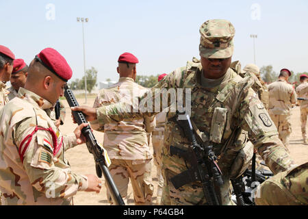 Stati Uniti Esercito prima Sgt. Gabriel Montgomery con 524th lottare contro il supporto del battaglione di supporto, xvii supporto brigata, Task Force battaglia Nato, emette un M16 fucile ad un soldato iracheno assegnato all'Iraq il 4° Battaglione, XXIII brigata, durante un iracheno addestrare ed equipaggiare fondo punto di emissione a Camp Taji, Iraq, 16 aprile 2016. Questo evento è uno dei vari dove gli Stati Uniti fornisce le armi o le altre attrezzature per i soldati iracheni per aiutarli a sconfiggere Daesh. (U.S. Esercito foto di Sgt. Kalie Jones/FOUO) Foto Stock