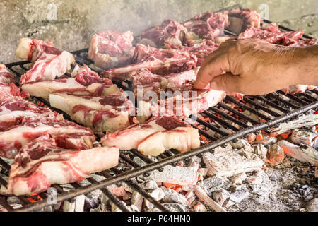 Grigliata di costolette di capra. Arrosto di carne su un barbecue in mattoni tipica barbecue in Sardegna, Italia. Messa a fuoco selettiva Foto Stock