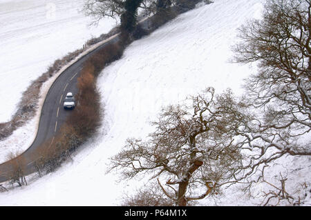 Una strada trattate con sale durante la neve vicino Frocester, Gloucestershire, Regno Unito Foto Stock