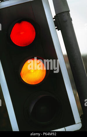 Il traffico che mostra le luci color ambra e rosso a un crocevia, UK. Foto Stock