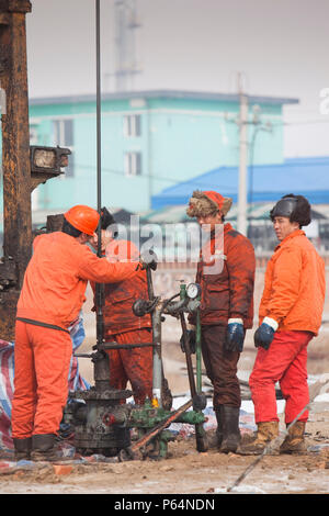 Lavoratori di olio la perforazione di un nuovo pozzo petrolifero di Daqing campo petrolifero nel nord della Cina Foto Stock