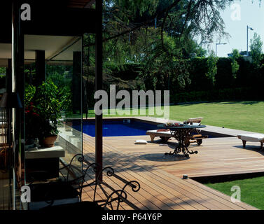 Vista di una chiara piscina accanto a un prato Foto Stock