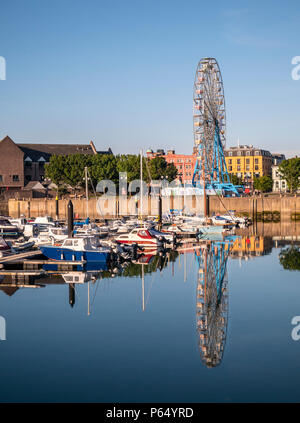 Una ruota panoramica Ferris riflessi nell'acqua di Bangor Marina, Co. Down, Irlanda del Nord Foto Stock