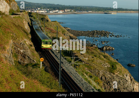 Un Dublin Area Rapid Transit (DART) UEM thread la sua strada in direzione sud lungo la spettacolare clifftop sezione tra Bray e Greystones. Foto Stock