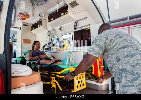 Stati Uniti Air Force Tech. Sgt. Damian Sharpe, xviii operazioni mediche Squadron NCO in carica di servizi di ambulanza, pratiche caricamento di un paziente nella parte posteriore di un'ambulanza Maggio 4, 2016 a Kadena Air Base, Giappone. La Kadena servizio ambulanza è molto occupato a rispondere a situazioni di emergenza in tutta l'isola, coprendo 50-60 chiede un mese. (U.S. Air Force foto di Airman 1. Classe Corey M. Pettis) Foto Stock