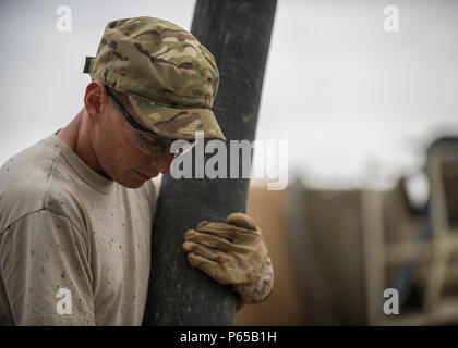 Senior Airman Giacobbe Nevills, 455th Expeditionary ingegnere civile Squadron sporco ragazzo, detiene un flessibile per dirigere il flusso di calcestruzzo per costruire i piè di pagina a Bagram Airfield, Afghanistan, 03 maggio 2016. Membri della 455th ECES stanno scavando fuori otto trincee per casa otto piè di pagina per il futuro posizionamento di quattro edifici riposizionabili. (U.S. Air Force foto di Senior Airman Justyn M. Freeman) Foto Stock