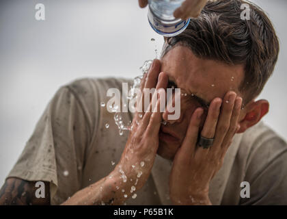 Senior Airman Giacobbe Nevills, 455th Expeditionary ingegnere civile Squadron sporcizia Boy, lavaggi del calcestruzzo dalla sua faccia dopo aver contribuiscono a colmare un piè di pagina a Bagram Airfield, Afghanistan, 03 maggio 2016. Membri della 455th ECES stanno scavando fuori otto trincee per casa otto piè di pagina per il futuro posizionamento di quattro edifici riposizionabili. (U.S. Air Force foto di Senior Airman Justyn M. Freeman) Foto Stock