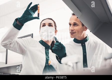 Laboratorio di concentrato gli scienziati indagando campione di sangue Foto Stock