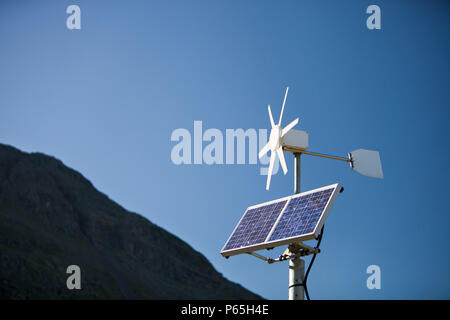 Un solare pannello elettrico e la turbina eolica essendo utilizzata per l'alimentazione di un neon di cartello stradale su Kirkstone Pass, Lakle distretto, UK. Foto Stock