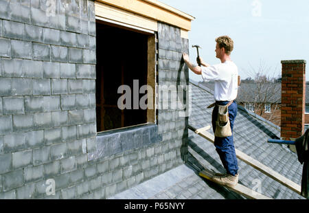 Copritetti mettendo le tegole di un tetto interno Foto Stock