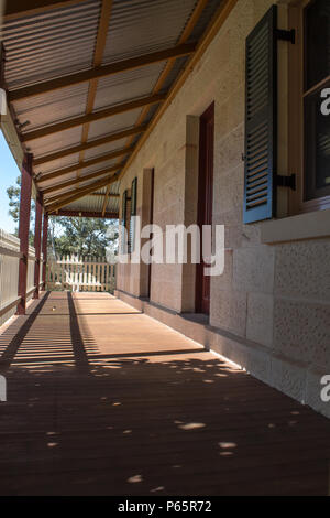 Veranda esterna coperta patio di mattoni di pietra arenaria cottage con Picket Fence nella luce del sole Foto Stock
