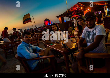 I turisti si siedono a Cafe del Mar ristorante situato sulle pareti di pietra, che circonda il coloniale città murata, al crepuscolo in Cartagena, Colombia. Foto Stock