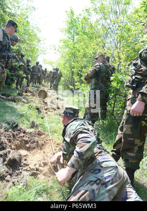 Un soldato Moldava dal nazionale Forze terrestri insegna soldati del reggimento squadrone tecnico, 2° reggimento di cavalleria, come rimuovere una miniera sepolta durante il rilevamento delle mine la porzione di formazione di esercizio pioniere Dragoon al Codru Area Formazione, Moldavia, Maggio10, 2016. (U.S. Foto dell'esercito da Staff Sgt. Steven M. Colvin) Foto Stock