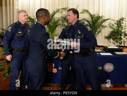 BATON ROUGE, Louisiana - Coast Guard Lt. Jonathan Scott, stati di Marine unità di sicurezza Baton Rouge, centro, scuote le mani con dello stato della Louisiana il sovrintendente di polizia Col. Michael Edmonson al momento della ricezione di una Louisiana Polizia di Stato meritorio servizio Award a Baton Rouge in Louisiana Polizia di Stato accademia di formazione, 10 maggio 2016. Scott e un altro membro della MSU Baton Rouge sono state riconosciute per la loro azione nel salvataggio e prevenire la U.S. Coast Guard foto di Sottufficiali di seconda classe Jonathan Lally. Foto Stock