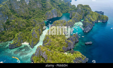 Antenna fuco vista delle imbarcazioni turistiche intorno alla bellissima grandi e piccole lagune in El Nido, Palawan Foto Stock