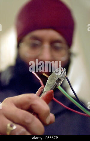 Elettricista lavorando su un alloggiamento progetto di ristrutturazione, a est di Londra. Foto Stock