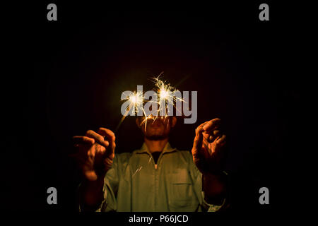 Close up di Mani botti di notte, fuochi d'artificio celebrano la notte Foto Stock