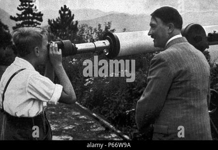 Adolf Hitler 1889-1945. gli indirizzi un rally 1936. Uomo politico tedesco e il leader del partito nazista. Egli era il cancelliere della Germania dal 1933 al 1945 e il dittatore della Germania nazista dal 1934 al 1945. Visto qui con un giovane ragazzo che guarda attraverso un telescopio al suo rifugio di montagna. Foto Stock