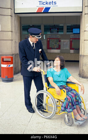 Una mano per un passeggero disabile a Londra, la stazione di Waterloo. C 1992 Foto Stock