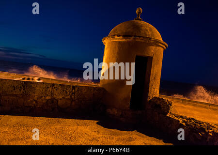 Una torre di avvistamento è visto durante il crepuscolo sulle vecchie mura difensive nelle mura della città di Cartagena, Colombia. Foto Stock