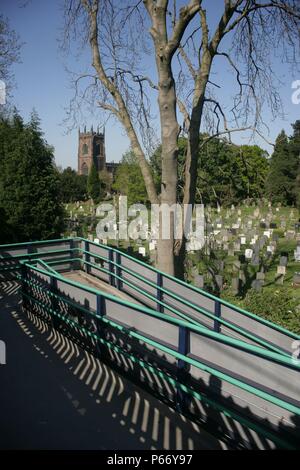 Rampe pedonali dalla piattaforma a Penkridge stazione, Staffordshire, con la chiesa del villaggio e il sagrato della chiesa al di là. 2007 Foto Stock