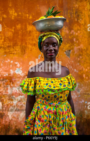 Una ragazza Afro-Colombian, vestito con il tradizionale 'palenquera' costume, posa per una foto a Cartagena, Colombia. Foto Stock