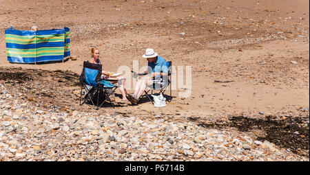 Un paio di mangiare pesce e patatine sulla spiaggia di Saltburn dal mare, England, Regno Unito Foto Stock