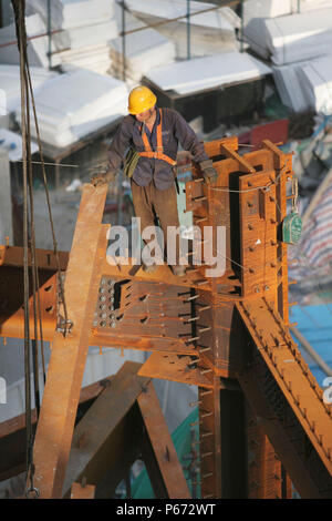 Operaio edile pearched su travi in acciaio Foto Stock