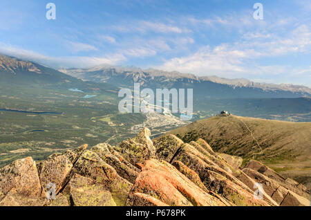 Vista da un roccioso, picco di montagna per i monti e la valle con la città in esso, foreste, fiumi e laghi Foto Stock