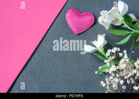 Cuore e bellissimi fiori sul grigio e sfondo rosa Foto Stock