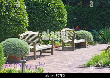 Due panche di legno in giardino Foto Stock