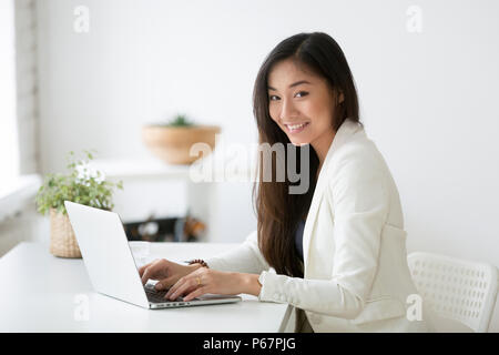 Ritratto di femmina professionale asiatici in posa sorridente in telecamera Foto Stock