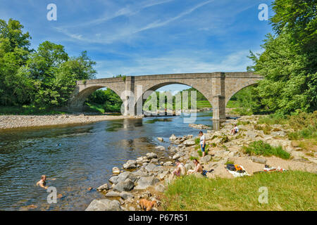 POTARCH ponte sopra il fiume Dee ABERDEENSHIRE una calda giornata estiva con persone e cani e nuoto PICNICING sulla riva del fiume Foto Stock