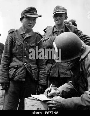 Fotografia di un coreano in costume della Wehrmacht in seguito alla cattura mediante i paracadutisti americani. Datata 1944 Foto Stock