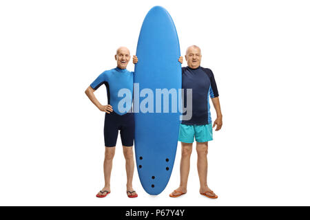 A piena lunghezza ritratto due anziani surfisti con una tavola da surf isolati su sfondo bianco Foto Stock