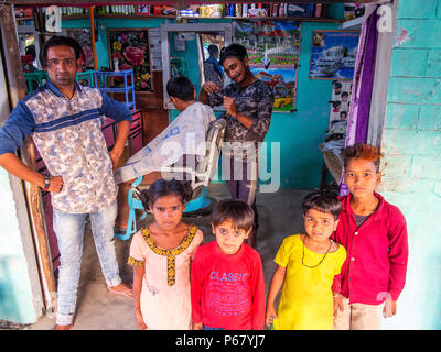 Bambini indiani in corrispondenza di un taglio di capelli Negozio a Pawalgarh, India Foto Stock