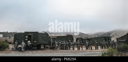 Come il sole che cerca di fare la sua strada sopra l'orizzonte, una lunga linea di soldati affamati raccoglie in cerca di un pasto caldo durante il 224th supporto della brigata 2016 annuale evento di formazione di Camp Roberts, 17 maggio. Alimentare gli specialisti del servizio da parte dell'unità di elemento di sede sarà trascorrere tre ore in preparazione della prima colazione e la cena al fine di nutrire gli affamati California esercito nazionale truppe di guardia ogni giorno. (U.S. Foto dell'esercito da Staff Sgt. Melissa legno/RILASCIATO) Foto Stock