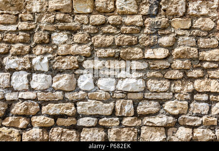 Pietra Grezza parete come creative texture di sfondo. Le pietre naturali della muratura con cuciture irregolari Foto Stock