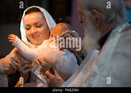 La Bielorussia, Gomel, 25 marzo. 2018. La Chiesa Prudhkovsky.Il rito del battesimo. Accettare la fede. Il sacerdote battezza il bambino Foto Stock