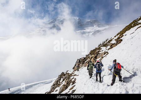 La cima del Monte Rainier si erge sopra le nuvole. Scalatori ed escursionisti sul sentiero Skyline, il Parco Nazionale del Monte Rainier, Washington, USA. Foto Stock